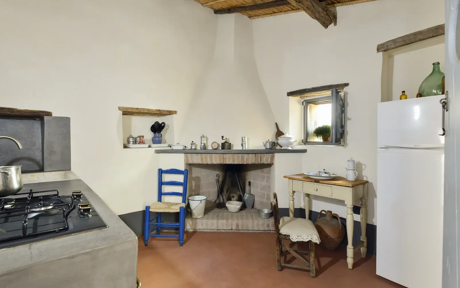 Cucina con camino, piano cottura e frigorifero