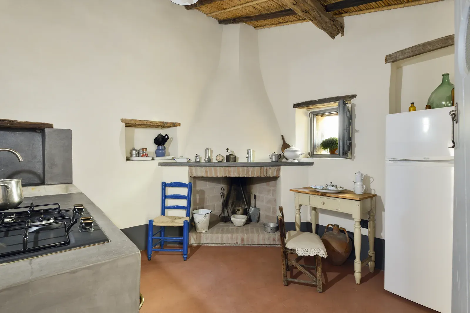 Cucina con camino, piano cottura e frigorifero