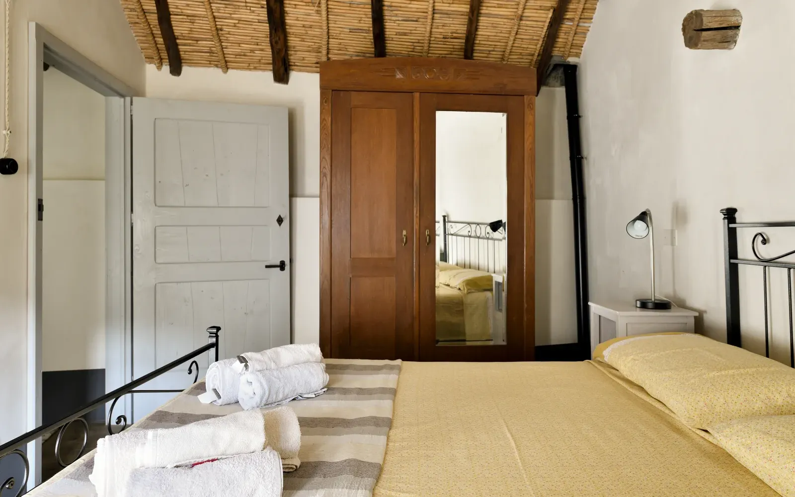 Camera vista dal corridoio, con la porta in legno aperta