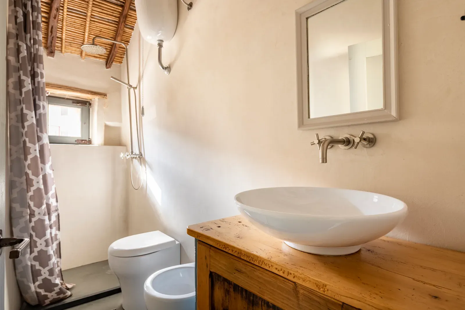Bagno con sanitari e mobile in legno chiaro