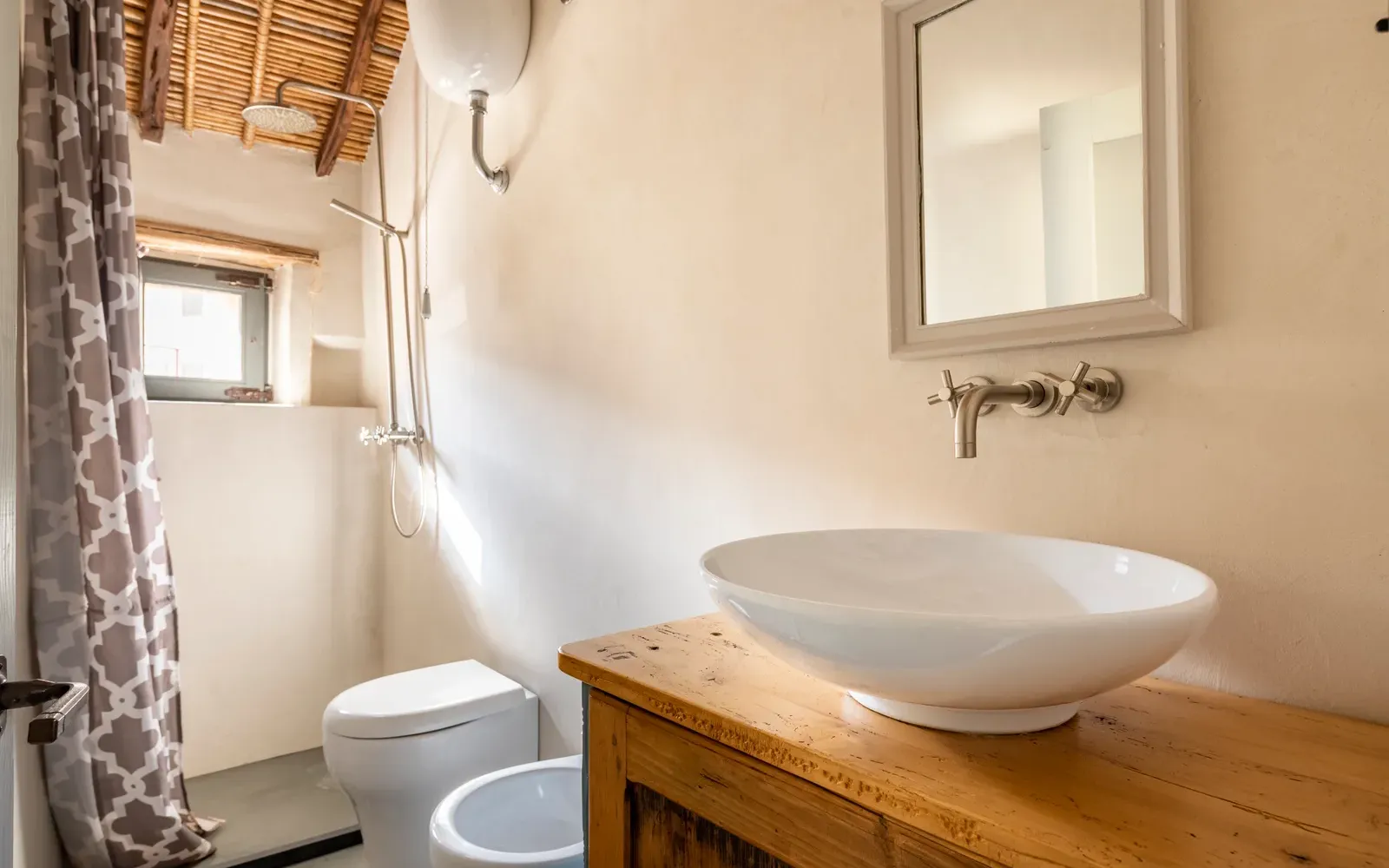 Bagno con sanitari e mobile in legno chiaro