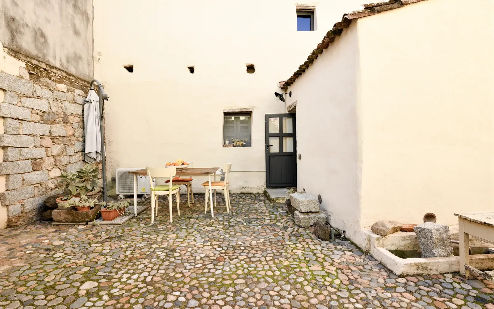 Il cortile acciottolato con tavolo e sedie