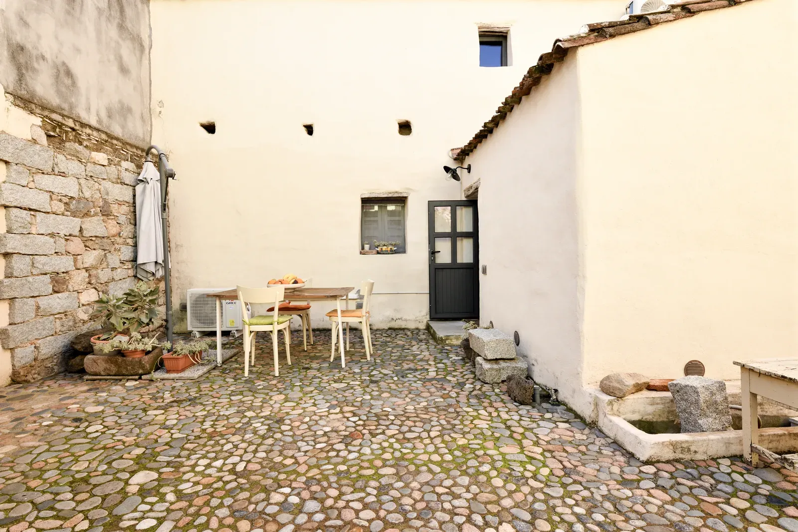Il cortile acciottolato con tavolo e sedie