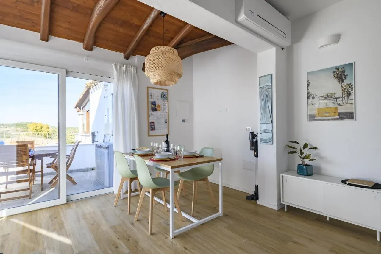 Zona giorno con grandi vetrate aperte sulla terrazza
