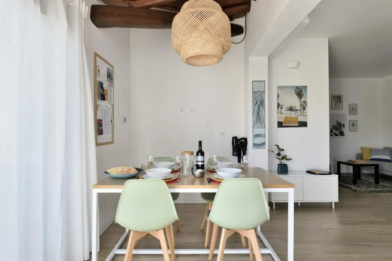 Il tavolo da pranzo con la tenda chiara alle spalle