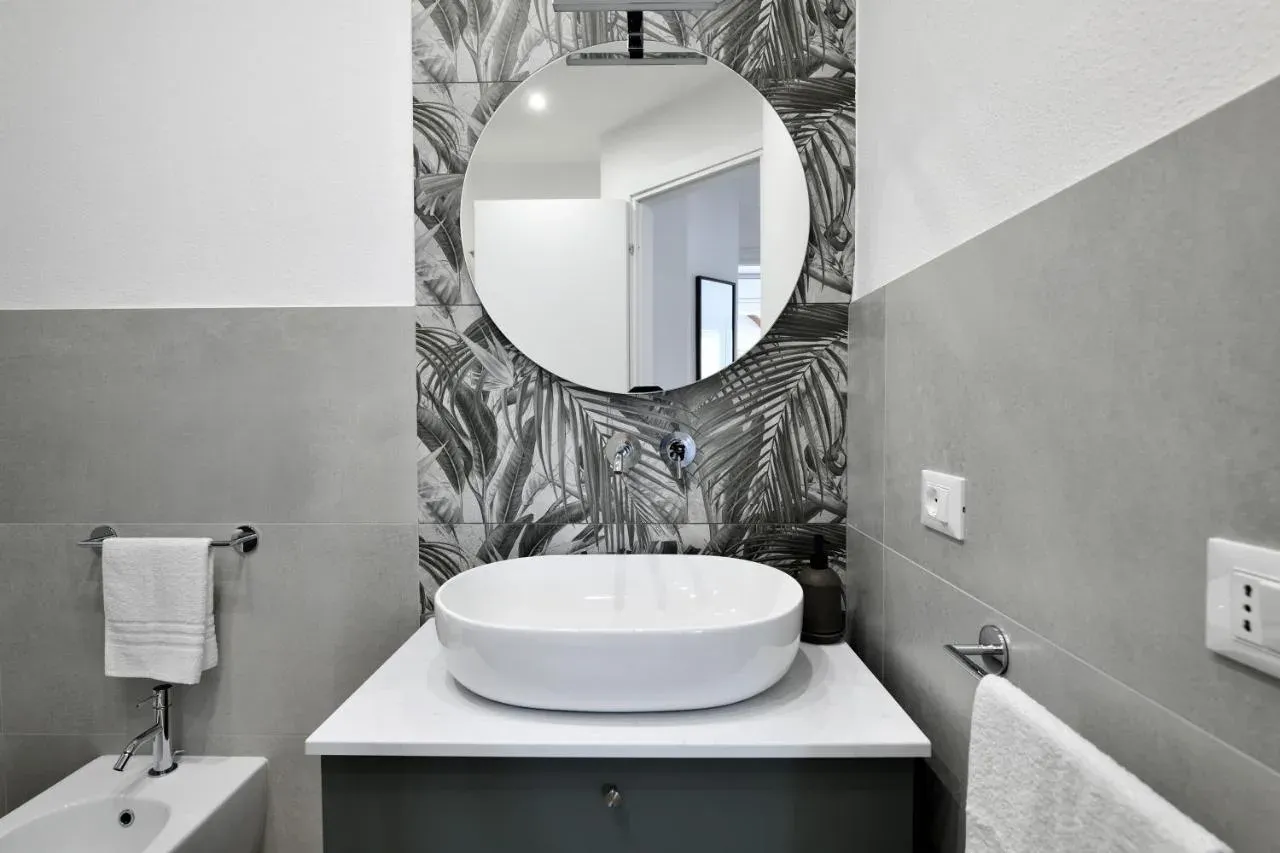 Bagno con lavabo a bacinella e specchio tondo